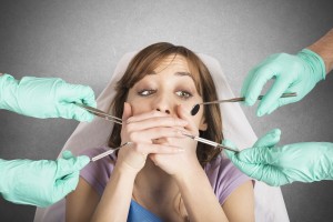 Girl frightened by dentists covers her mouth